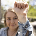 Amanda Mehl holds up her tattood wrist.