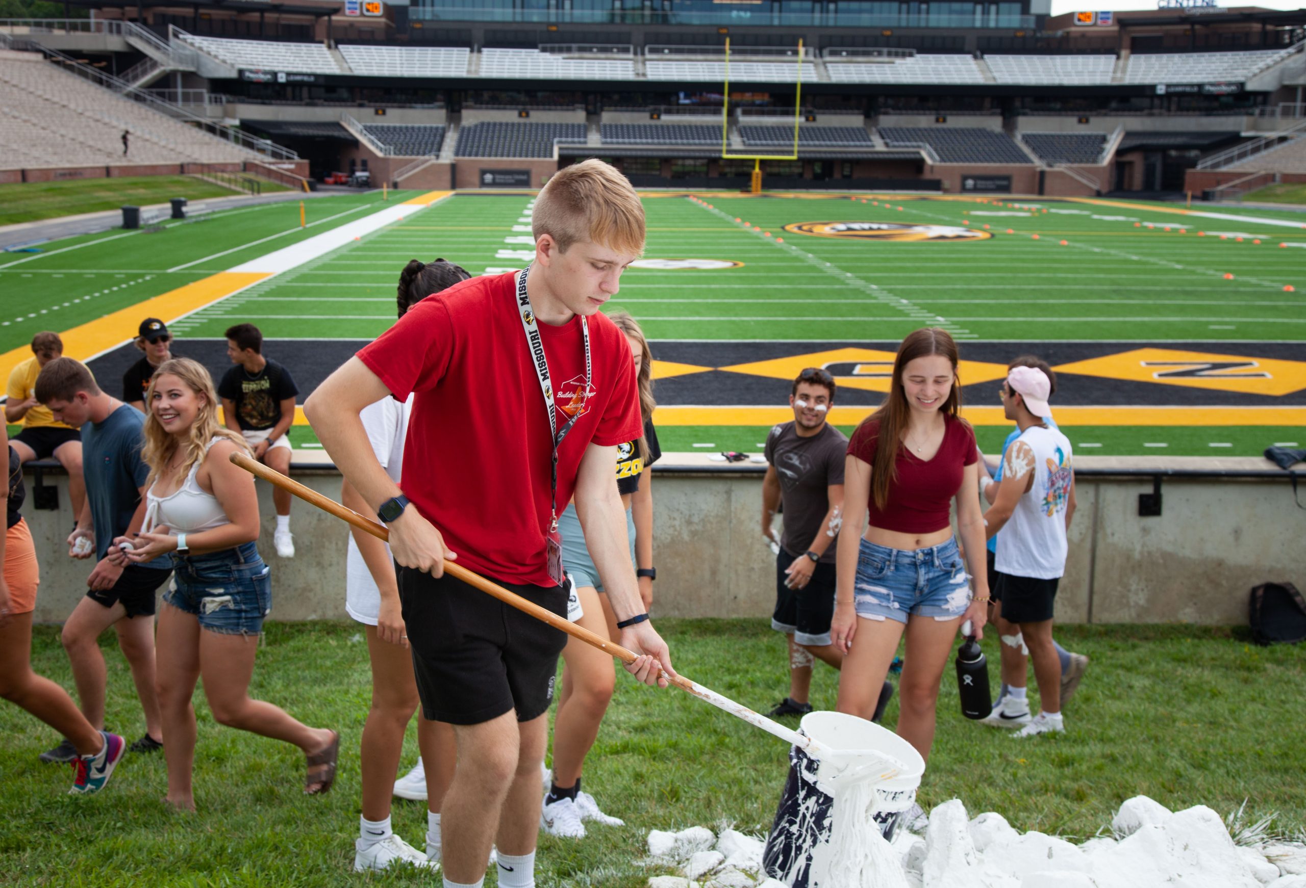 Students participate the painting the rock M at Faurot Field