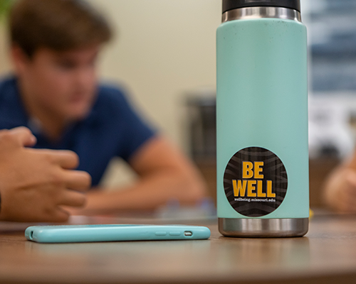 Be Well sticker on water bottle.