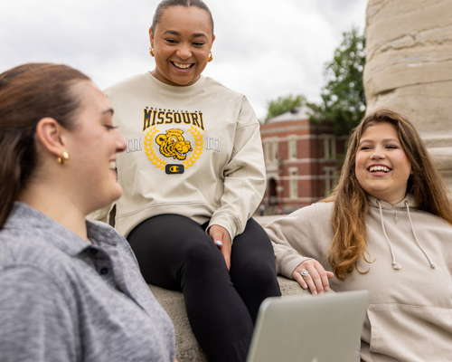 Students smiling on the columns